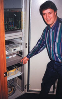 Tom Weller, Substation and Metering Engineer, points to equipment rack with TC2100 Multi-Drop Fiber Modem.
